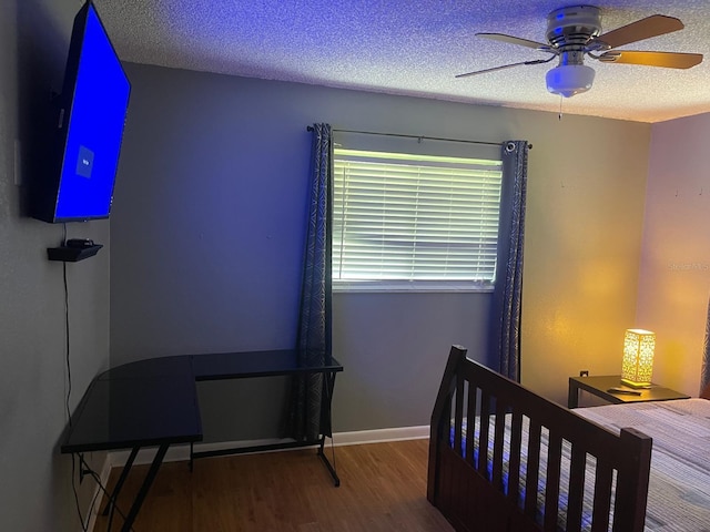 bedroom featuring hardwood / wood-style flooring, ceiling fan, and a textured ceiling