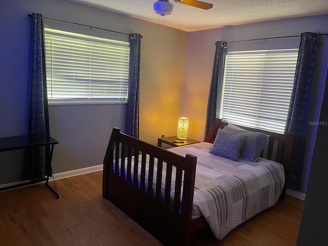 bedroom with hardwood / wood-style flooring, a textured ceiling, and ceiling fan