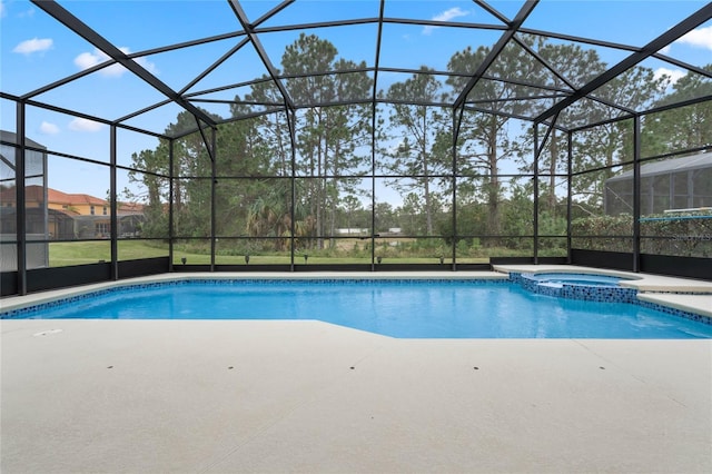 view of swimming pool with a patio, glass enclosure, and an in ground hot tub