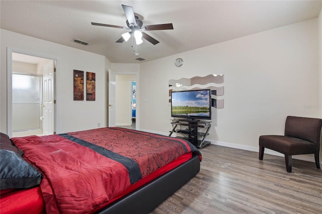 bedroom with hardwood / wood-style flooring, ceiling fan, and ensuite bath