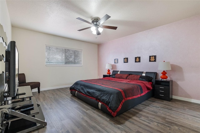 bedroom featuring dark hardwood / wood-style flooring, a textured ceiling, and ceiling fan