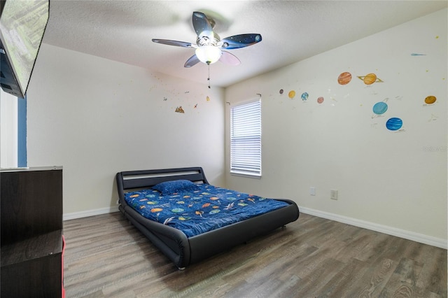 bedroom with hardwood / wood-style flooring, a textured ceiling, and ceiling fan