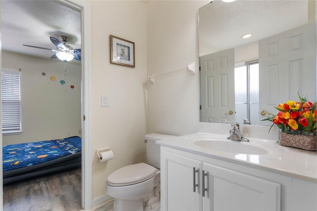 bathroom with toilet, vanity, a textured ceiling, and hardwood / wood-style flooring