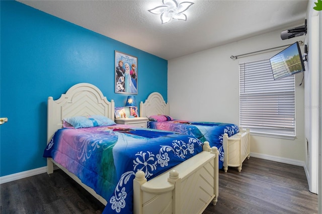 bedroom featuring a textured ceiling and dark hardwood / wood-style flooring