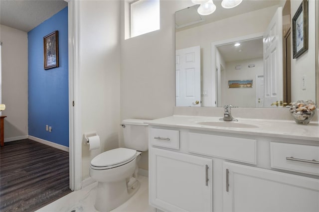 bathroom with toilet, vanity, and a textured ceiling