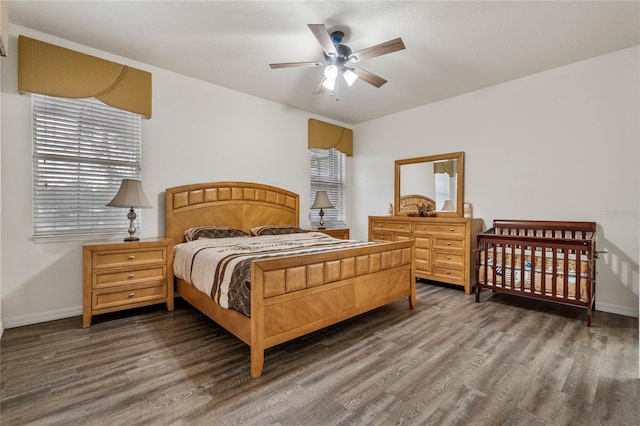 bedroom with multiple windows, ceiling fan, and dark hardwood / wood-style floors