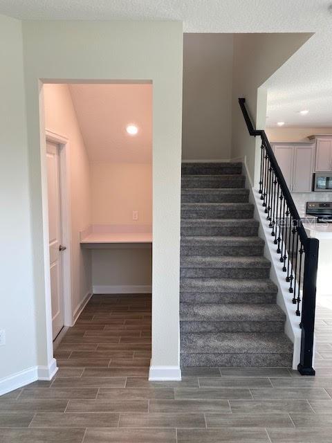 staircase featuring a textured ceiling