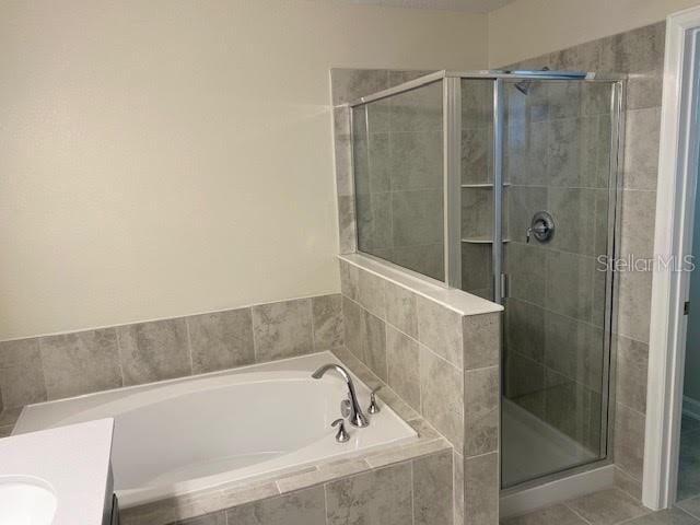 bathroom with vanity, tile patterned floors, and shower with separate bathtub