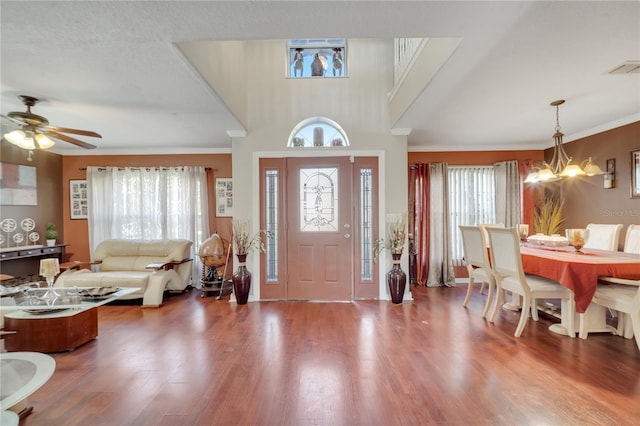 entryway with ceiling fan with notable chandelier, a wealth of natural light, and hardwood / wood-style floors