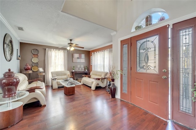 foyer entrance with hardwood / wood-style flooring, ceiling fan, a wealth of natural light, and ornamental molding