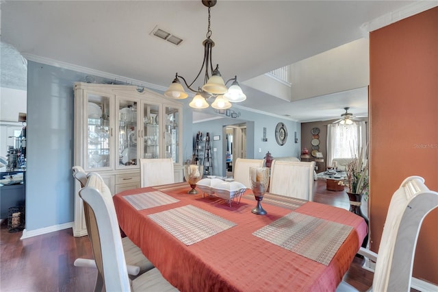 dining area featuring dark hardwood / wood-style floors, crown molding, and ceiling fan with notable chandelier