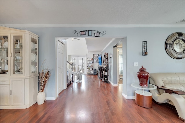 foyer featuring dark wood-type flooring, french doors, and crown molding