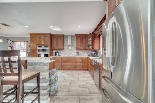 kitchen featuring decorative light fixtures, stainless steel appliances, wall chimney range hood, tasteful backsplash, and crown molding