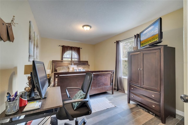 bedroom with a textured ceiling and hardwood / wood-style floors