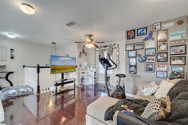 living room with ceiling fan, dark hardwood / wood-style flooring, and a textured ceiling