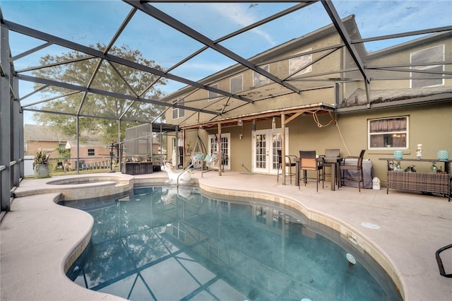 view of pool featuring french doors, glass enclosure, an in ground hot tub, and a patio area