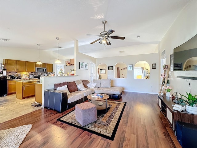 living room with lofted ceiling, hardwood / wood-style floors, a wealth of natural light, and ceiling fan