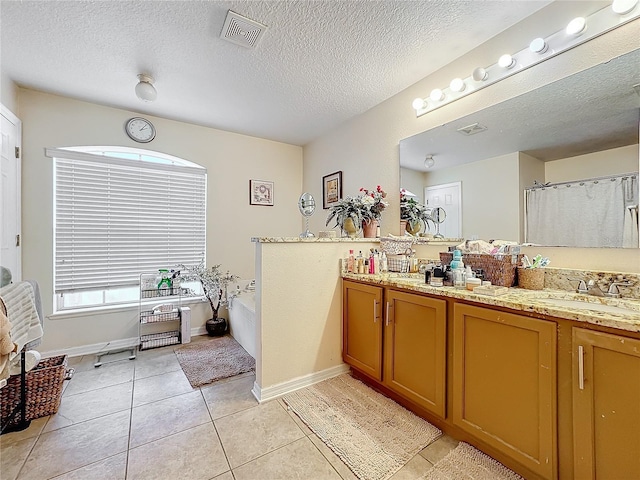 bathroom with tile patterned floors, shower with separate bathtub, a textured ceiling, and vanity