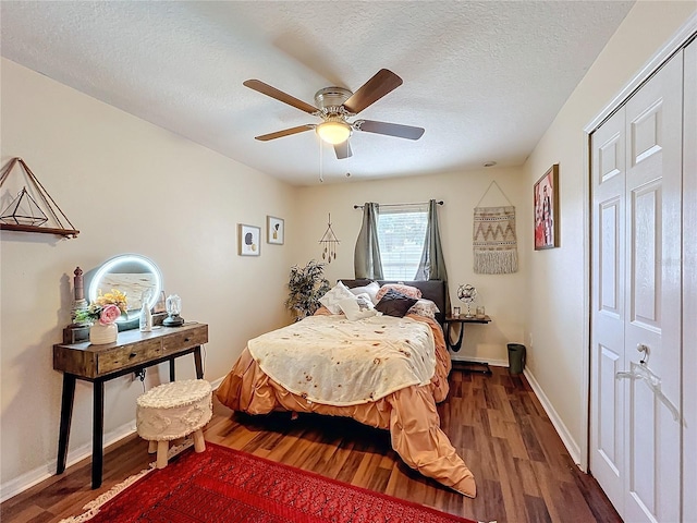 bedroom featuring dark hardwood / wood-style floors, a textured ceiling, ceiling fan, and a closet