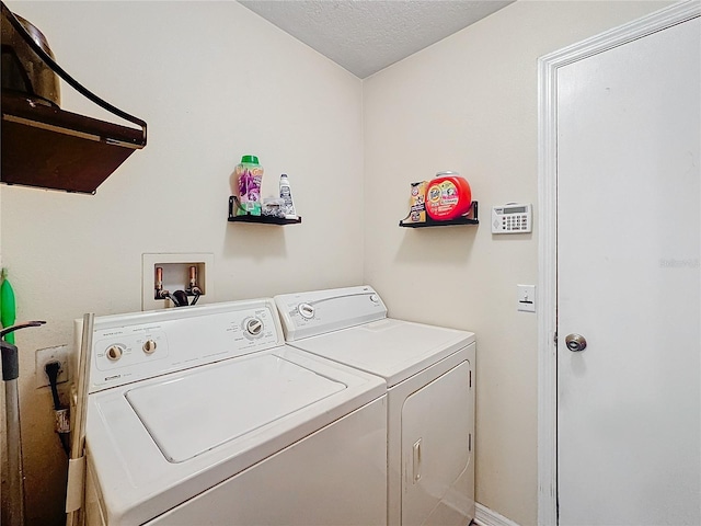 clothes washing area featuring washer and clothes dryer and a textured ceiling