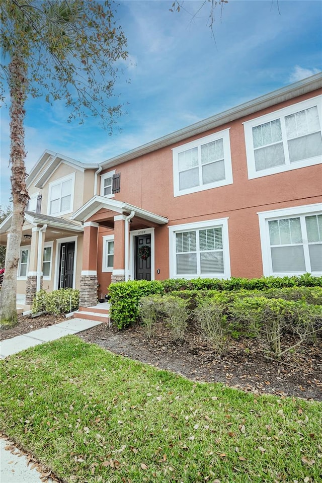 townhome / multi-family property featuring a front yard