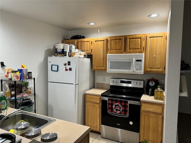 kitchen featuring sink, white appliances, and light tile patterned flooring