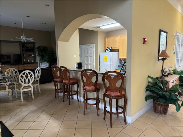 tiled dining space with ceiling fan