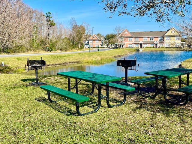 view of home's community with a lawn and a water view