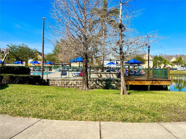 view of property's community featuring a yard and a water view