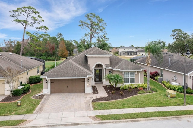 view of front of home featuring a garage, a front yard, and central air condition unit