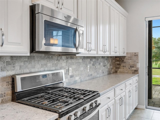 kitchen featuring stainless steel appliances, white cabinetry, tasteful backsplash, and a healthy amount of sunlight