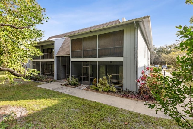 rear view of property featuring a lawn