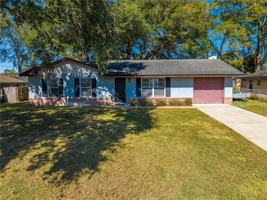 single story home featuring a front lawn and a garage