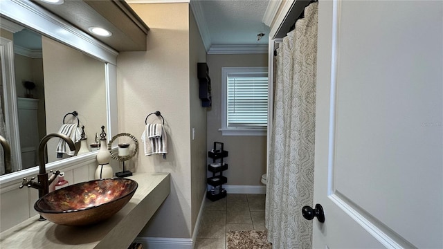 bathroom featuring sink, a textured ceiling, tile patterned flooring, ornamental molding, and toilet