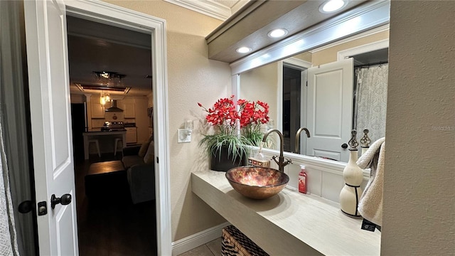 bathroom featuring tile patterned flooring, crown molding, and sink