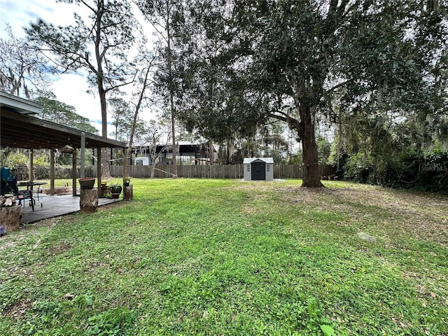 view of yard featuring a deck and a storage shed