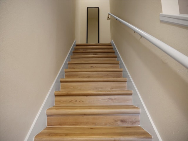 stairs featuring hardwood / wood-style floors