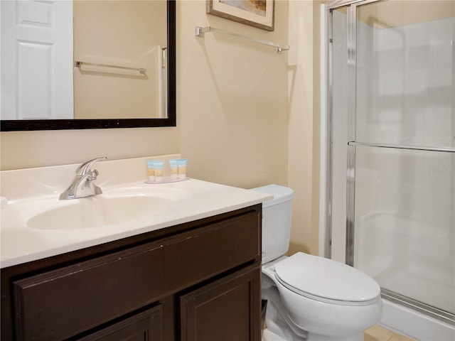 bathroom with toilet, a shower with door, and vanity