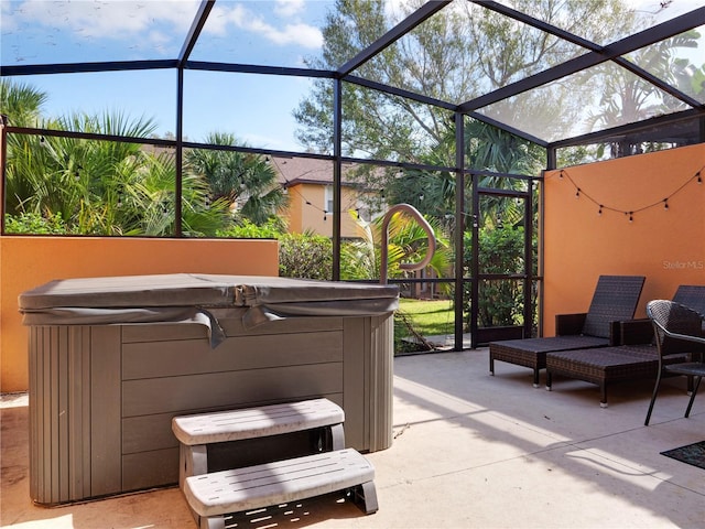 view of patio / terrace featuring a lanai and a hot tub