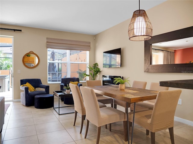 dining space featuring baseboards, light tile patterned flooring, and a healthy amount of sunlight