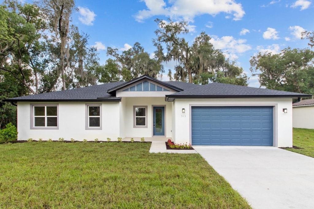 ranch-style house featuring a garage and a front lawn