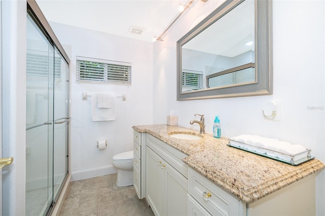 bathroom with toilet, a shower with door, and vanity