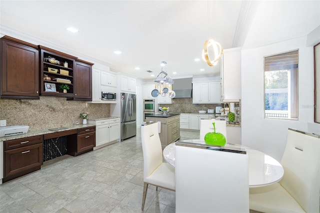 kitchen featuring appliances with stainless steel finishes, backsplash, white cabinetry, and decorative light fixtures