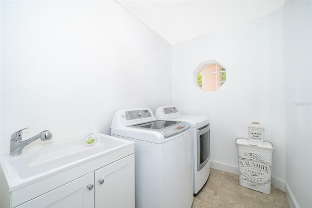 washroom featuring cabinets, sink, and washing machine and dryer