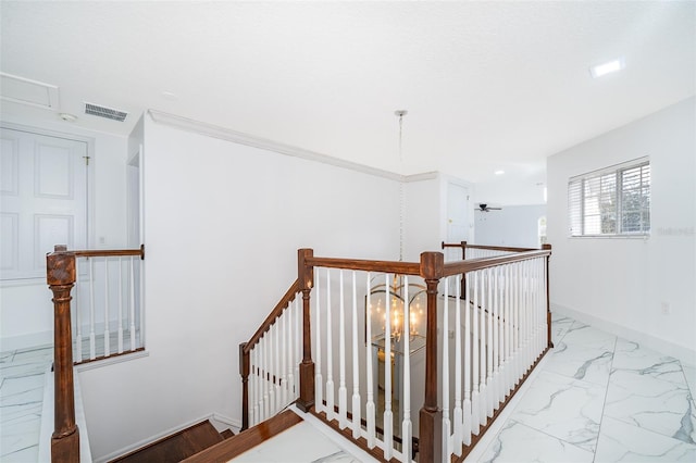 stairway featuring ornamental molding and ceiling fan with notable chandelier