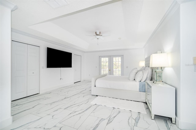 bedroom with ceiling fan, a tray ceiling, ornamental molding, and french doors