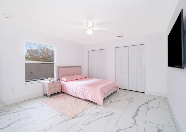 bedroom with ceiling fan and multiple closets