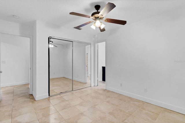 unfurnished bedroom with ceiling fan and a closet