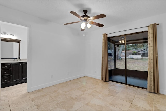 unfurnished room featuring a textured ceiling, ceiling fan, and sink