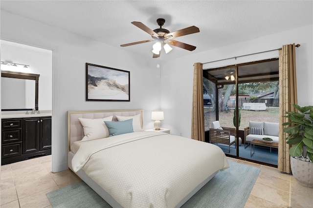 bedroom featuring ensuite bathroom, ceiling fan, access to exterior, and a textured ceiling